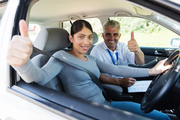 Student driver and instructor giving thumbs up