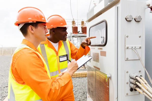 Industrial electricians taking machine readings