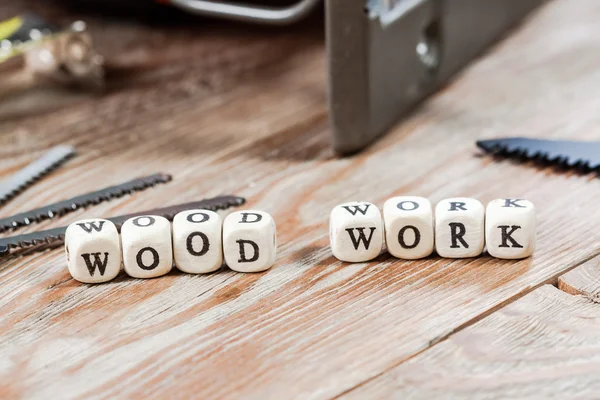 Word WOOD WORK written on a wooden block.