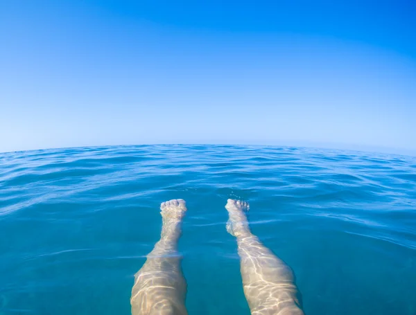 Sea blue view from first person with legs