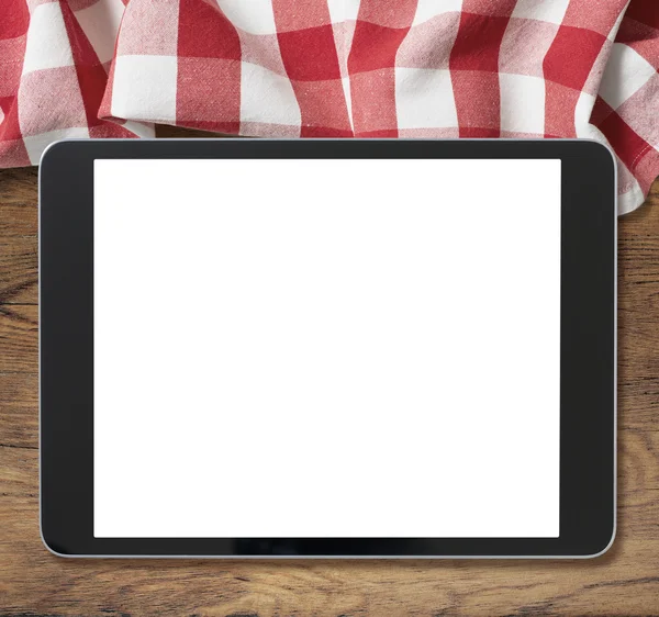 Black tablet pc on wooden table and picnic tablecloth