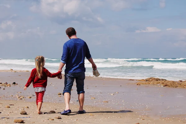 Father and daughter walking on the beach