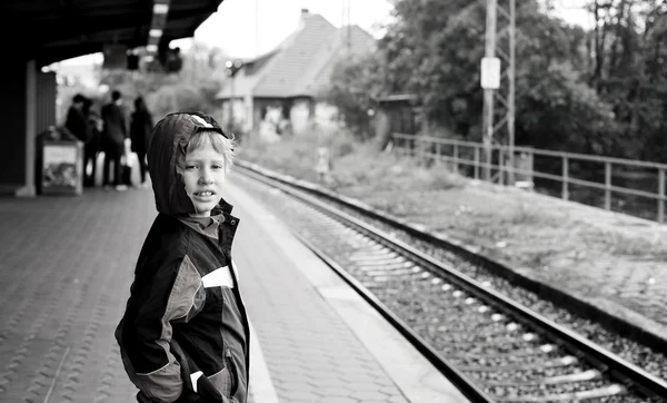 Little boy standing on railway station