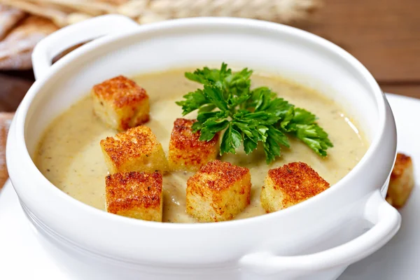 Vegetable soup with pieces of toasted bread and parsley.