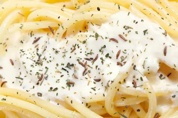 Cooked pasta with cream sauce.
