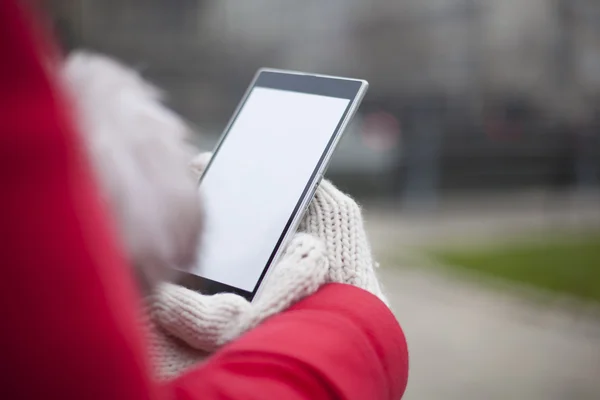 Mobile phone in hands with glowes, cold weather