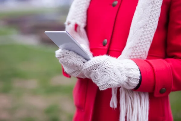 Woman in wool gloves hold smart-phone