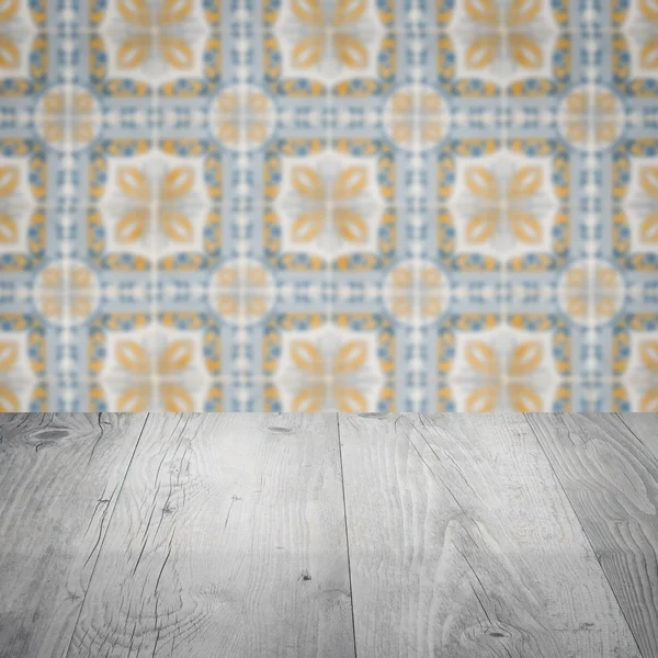 Wood table top and blur ceramic tile pattern wall