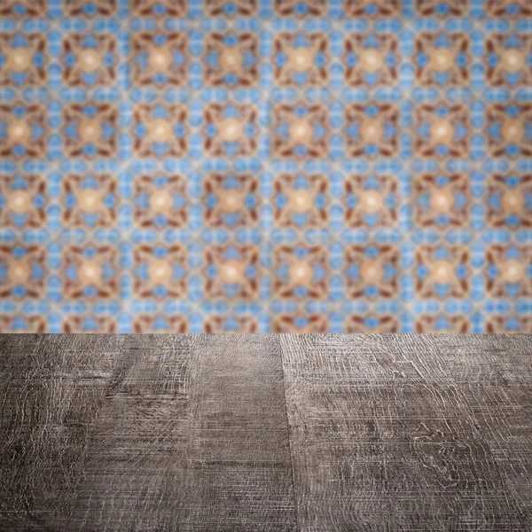 Wood table top and blur vintage ceramic tile pattern wall