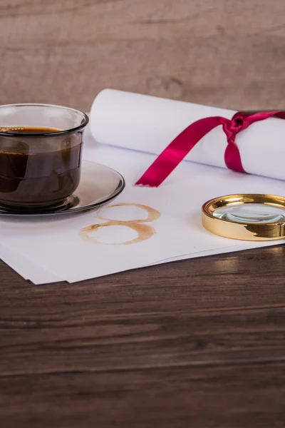 Coffee cup, paper sheets and detective hat