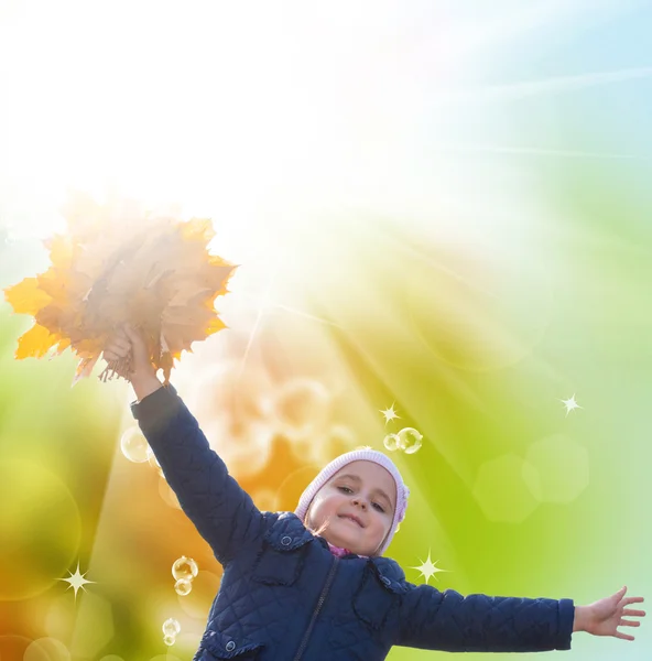 Happy Little Girl with bouquet autumn yellow dry leaves