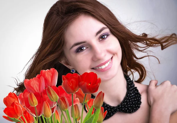 Beauty Woman with Beautiful bouquet fresh red tulips