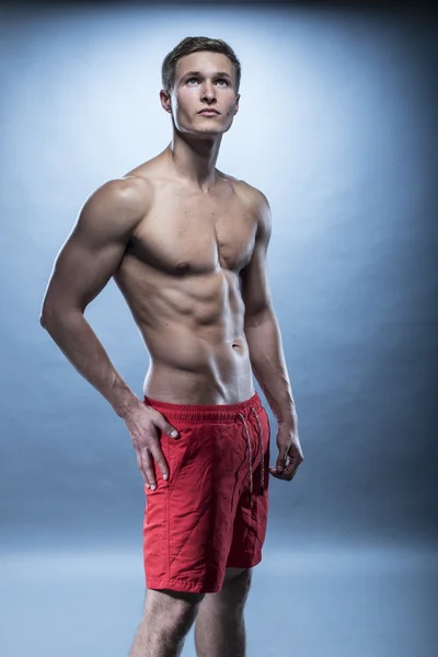 Male fitness model wearing red shorts