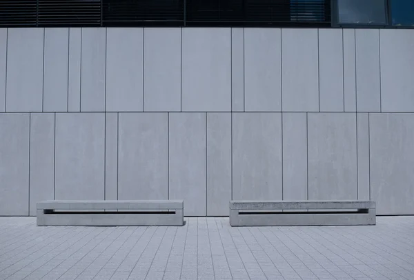 Two Similar Benches Against White Building Wall