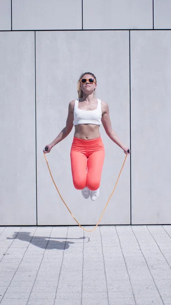 Energetic Young Woman Exercising with Jumping Rope