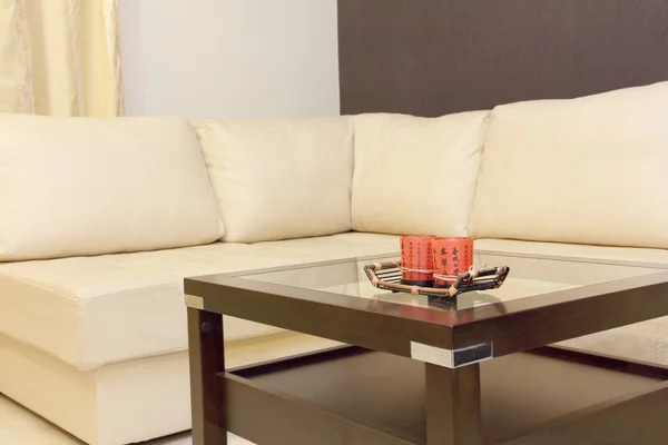 Coffee table and white corner leather sofa .