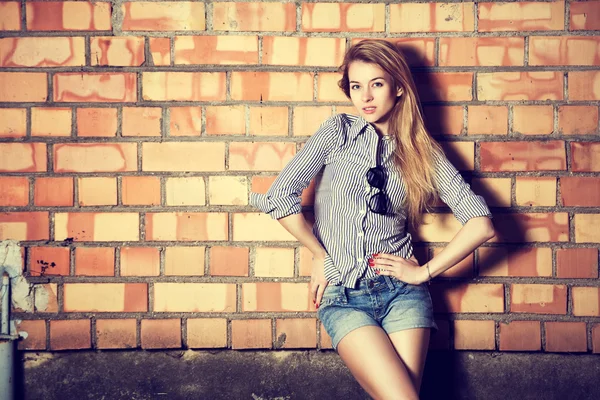 Trendy Fashion Girl at the Brick Wall