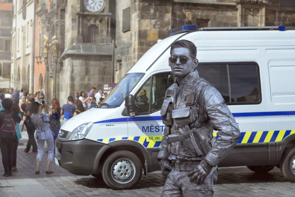 Meme-artist in the form of futuristic police posing on old Town Square in the background of the old town hall (Staromestske namesti), Prague