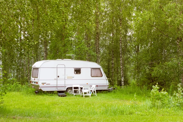 Camping van on a green meadow. Palvaanjarven Campsite