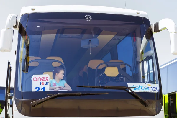 Girl posing in tourist bus with Anex Tour logo at Heraklion Airport