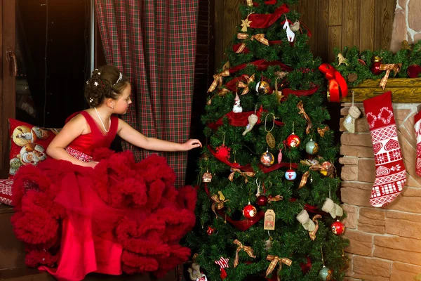Little winter Princess, girl decorates Christmas tree