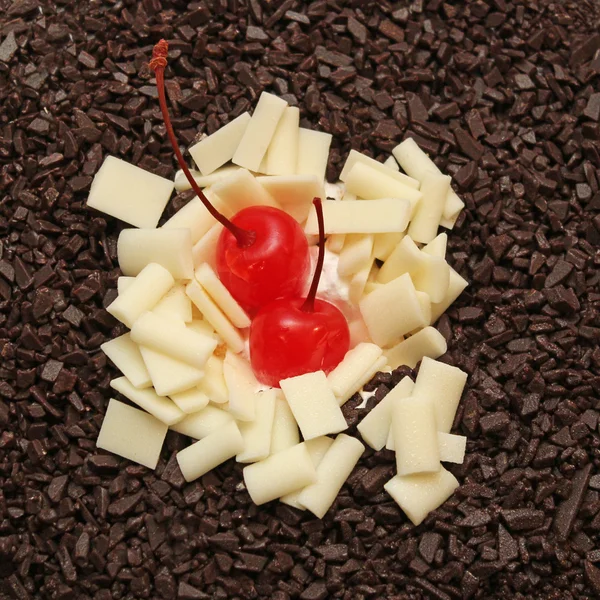 Maraschino cherry on a white and dark chocolate. Cherry on the cake.