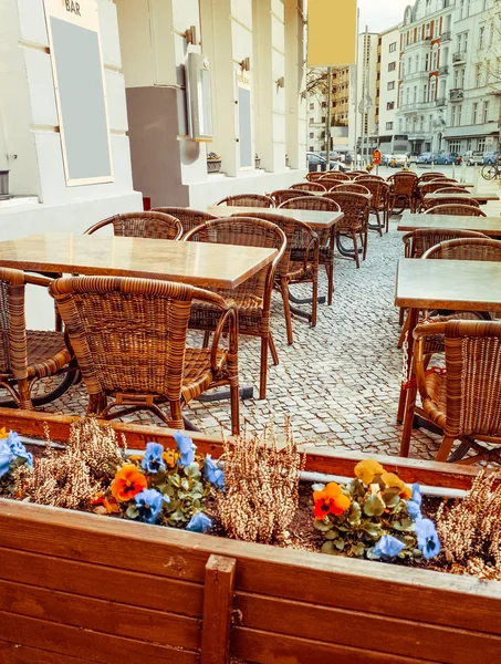 Street view of a coffee terrace with tables and chairs