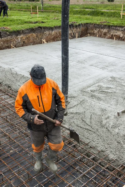 Worker pouring concrete mix.