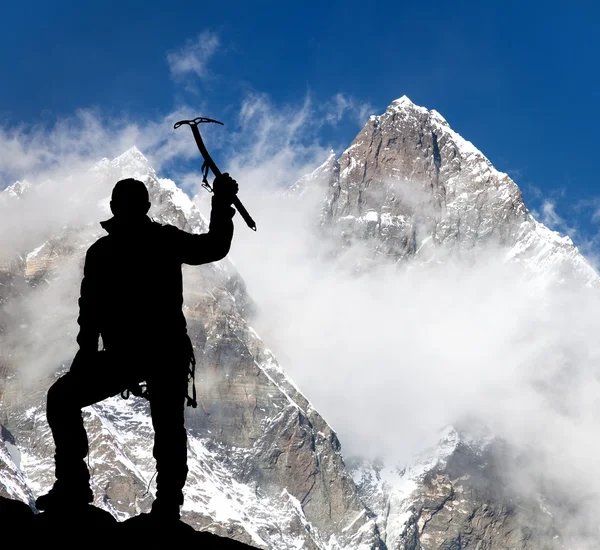 Mount Lhotse and silhouette of man wirh ice axe