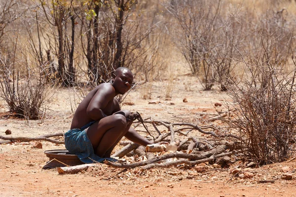 Himba man adjusts wooden souvenirs