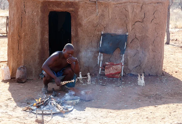Himba man adjusts wooden souvenirs