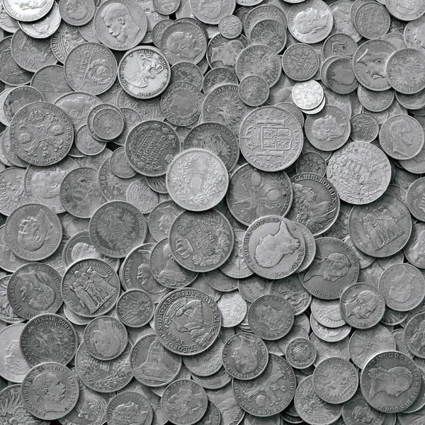 Ancient silver coins in a background photo.