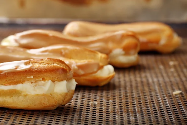 Sweet eclairs with cream. Catering set.