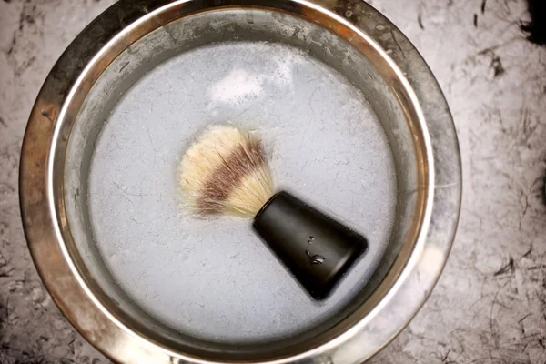 Shaving brush in a bowl in barber shop
