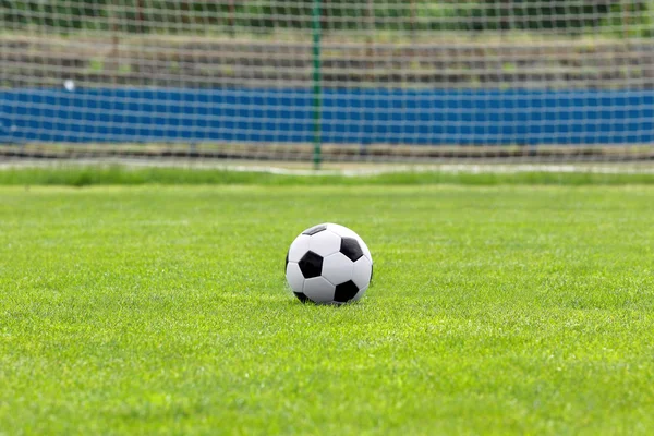 Soccer ball on football green field with space for text