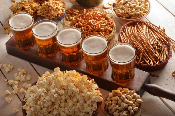 Beer and snacks on wooden background football fan set
