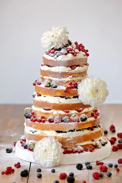 Wedding rustic naked cake with flowers on wooden background