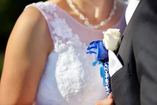 Groom with wedding blue rose buttonhole outdoors