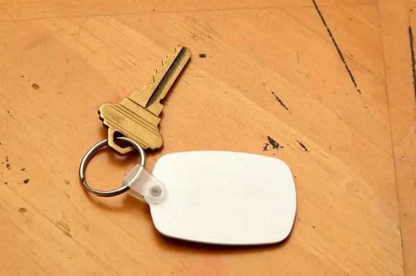 Keyring with key and white fob on wood table