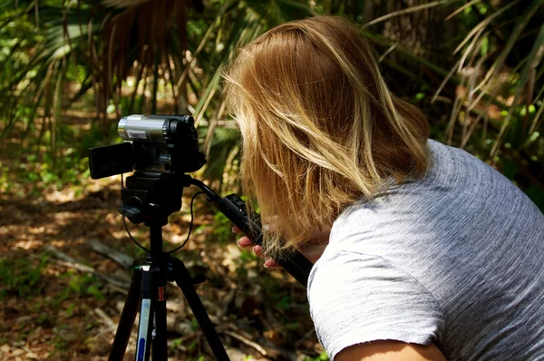 Woman using video camera outdoors