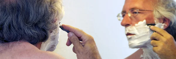 Man shaving in mirror