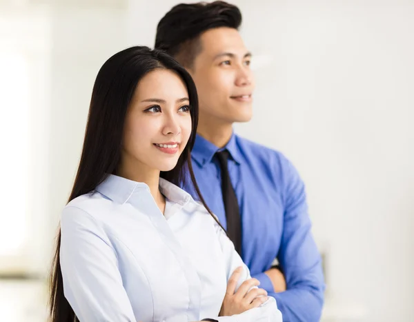Young business man and woman standing in office