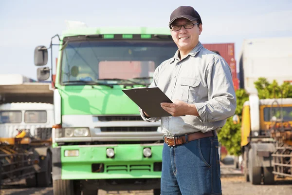 Happy truck driver writing on a document