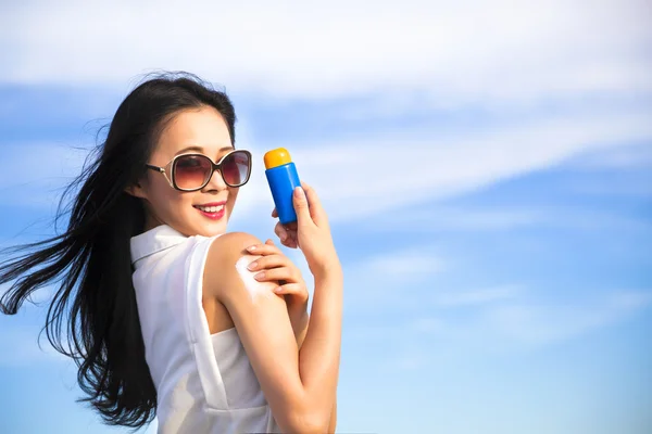 Young woman applying sun protection lotion