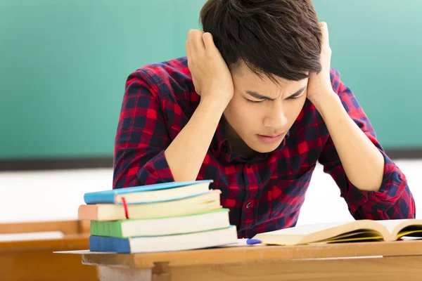 Stressed student  studying for exam in classroom