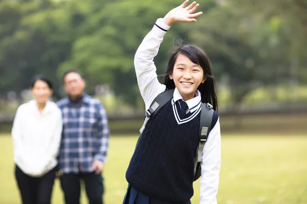 Cute young student girl with parent in school