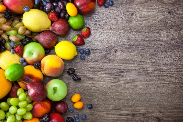 Colorful Fruits on wooden Table with water drops and copy space