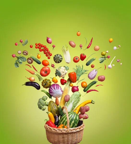 Studio photography of different fruits and vegetables on green background, top view.