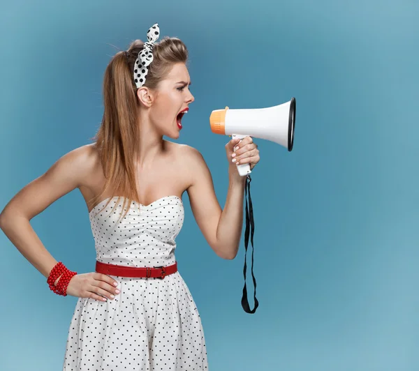 Nervous pin-up girl screaming with megaphone, mouthpiece, speaking trumpet. Filmmaking or film production concept