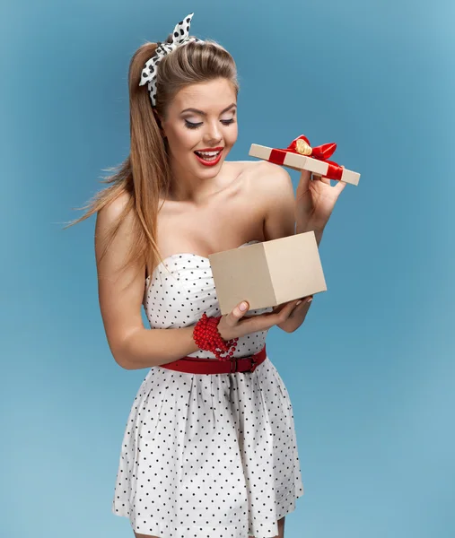 Excited young girl opening present box